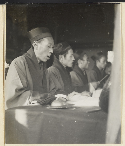 Daoist priests chanting and playing instruments during funeral service