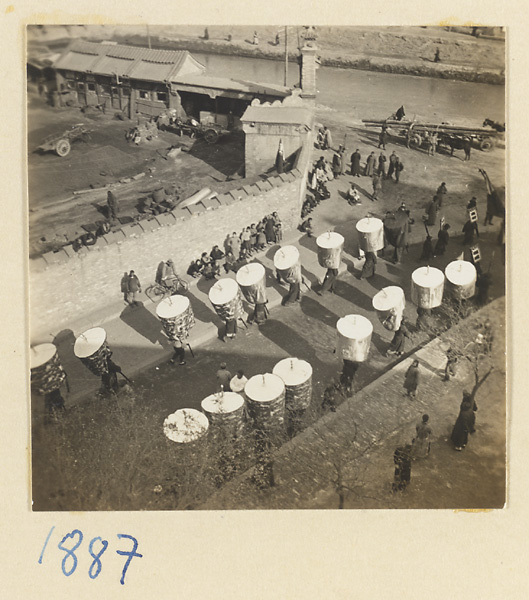 Funeral procession with umbrellas near city moat