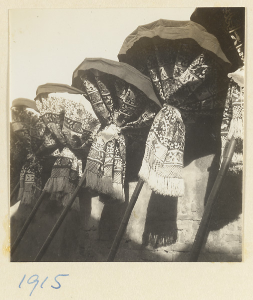 Umbrellas for funeral procession tied and resting against a wall