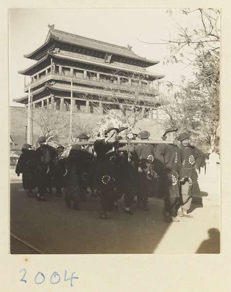 Members of a funeral procession carring a wreath, by Zhengyangmen (正阳门) / Qianmen (前门), Beijing