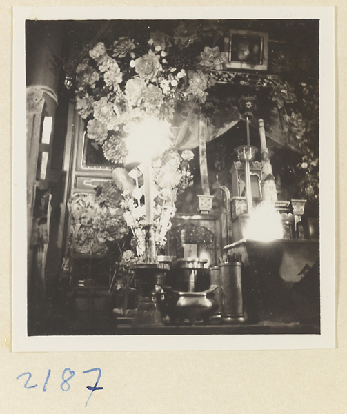 Temple interior on Miaofeng Mountain showing an altar with flowers, candles, and burning incense