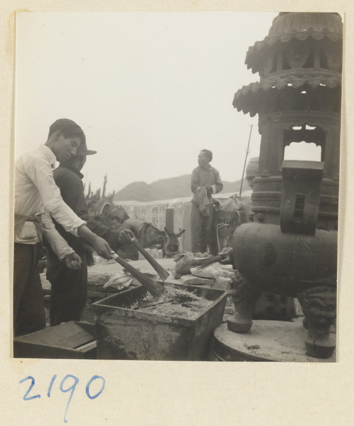 Pilgrims burning incense in metal incense burners on Miaofeng Mountain