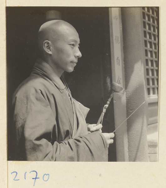 Monk holding a handchime on Miaofeng Mountain