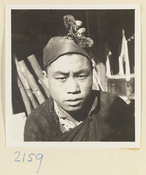 Boy wearing a hat with souvenir decorations on the pilgrimage trail on Miaofeng Mountain