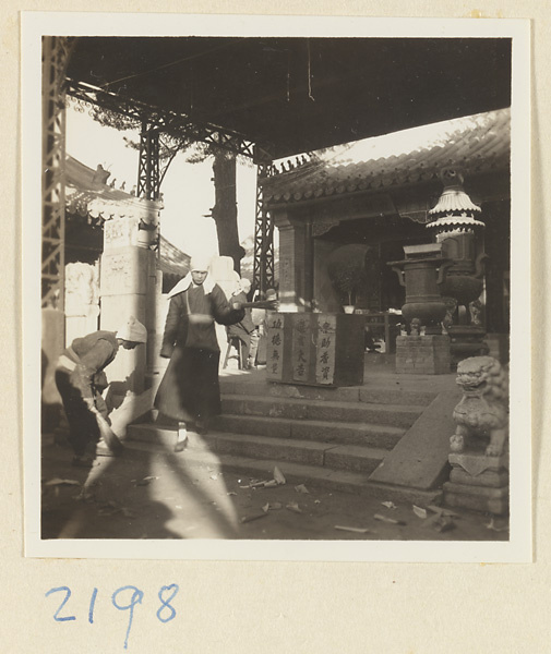 Pilgrims with incense under a canopy at the entrance to a temple building on Miaofeng Mountain