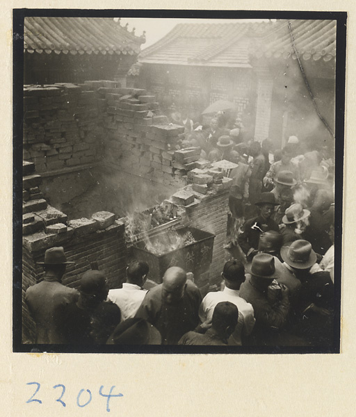 Pilgrims next to a brick incense burner on Miaofeng Mountain