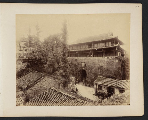 Looking over tiled roofs toward Canton city wall and gate