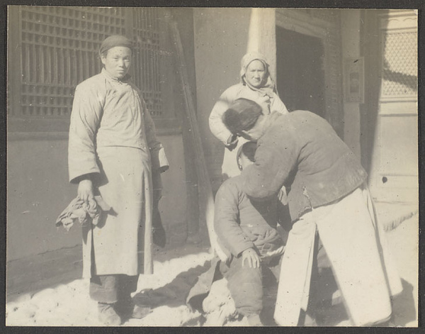 Women watching street dentist (?) at work