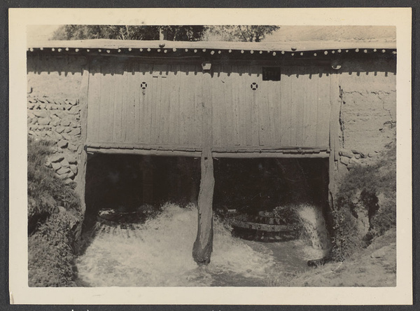 In the Great Hsia.  A Tsinghai flour mill.  Wheel on left revolving.  Bottom stone of mill above revolves.  Upper stone suspended by a number of ropes.