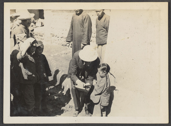 Sining.  Dr. Z. reading a girl's 'horn book' of Arabic.