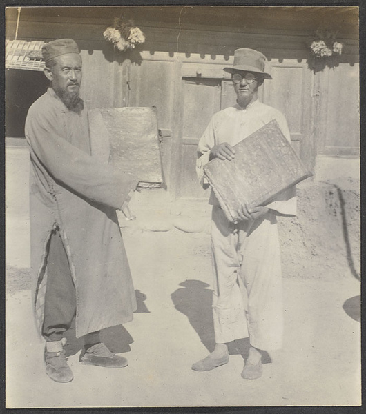 Kehtsikung, Tsinghai. Two Salar farmers holding the holy Koran with unclean hands.