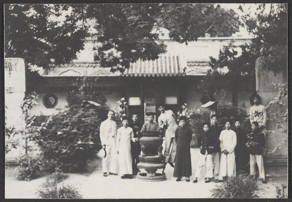 People in courtyard with incense burner and stelae