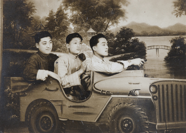 Studio portrait of three men in a 'jeep'