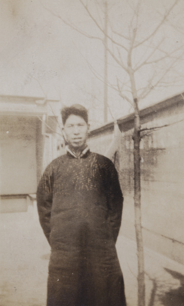 An unidentified man standing by a wall