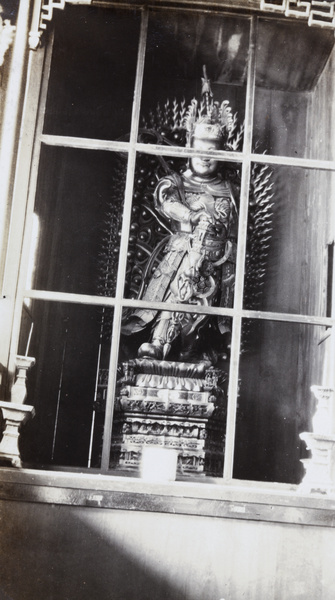 Shrine with sculpture behind a window