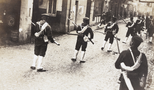 Japanese marines with bayonets patrol a Shanghai street