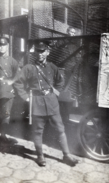 Chinese Shanghai Municipal Police with a man in a holding cage on a lorry