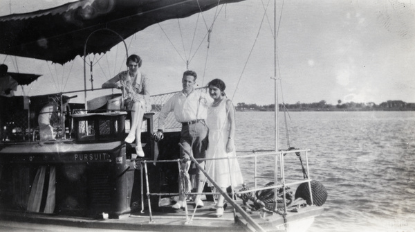 John Montgomery with two women on the houseboat 'Pursuit'