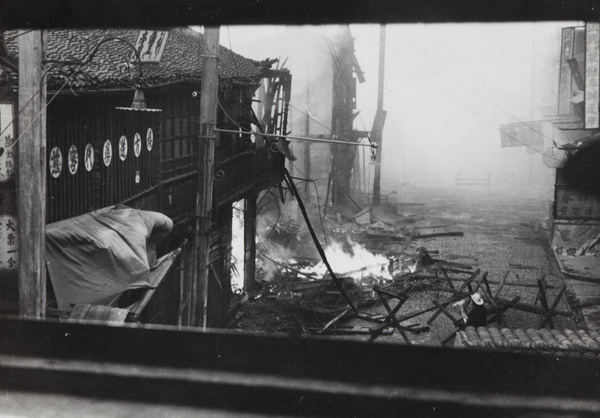 Firefighter in street ablaze with flames and thick with smoke, Shanghai, 1937