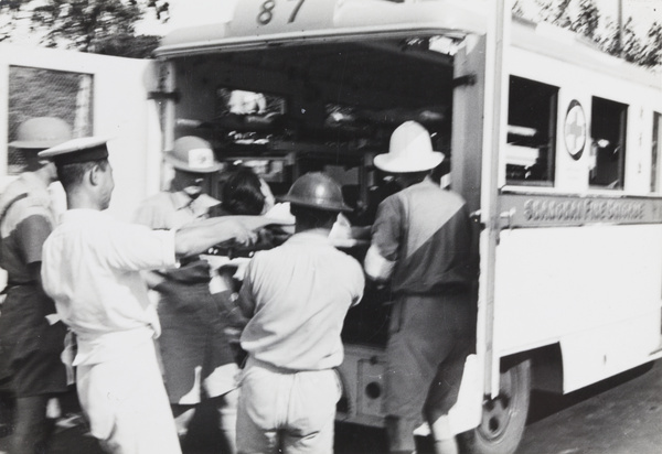 A casualty on a stretcher being placed in a Shanghai Fire Brigade ambulance, Shanghai, 1937