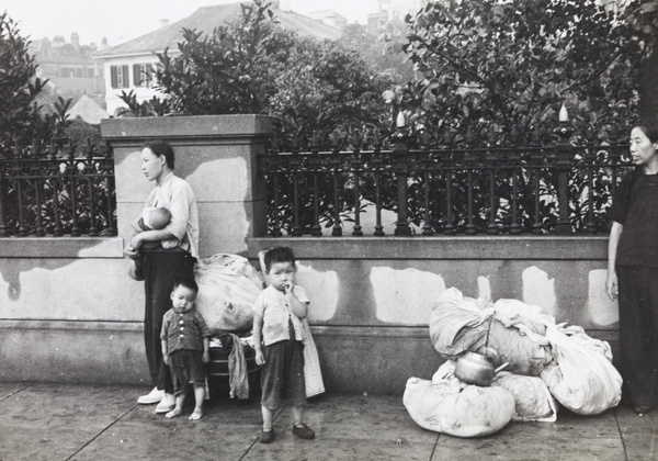 Women refugees with children and bundles of possessions, outside the British Consulate, Shanghai, 1937