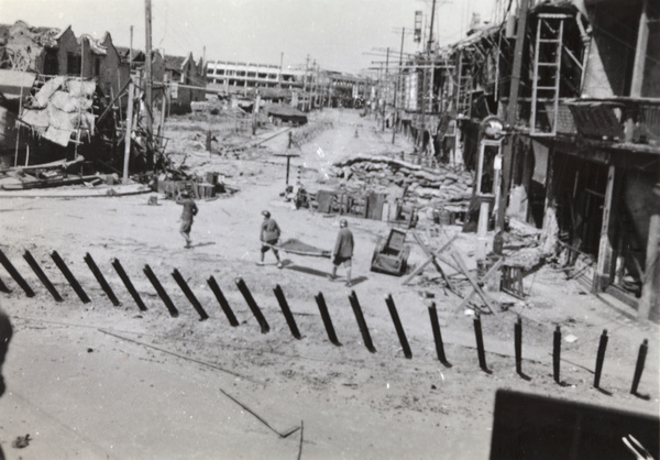 Chinese soldiers with a casualty on a stretcher, crossing Honan Road and Range Road, Shanghai, 1937