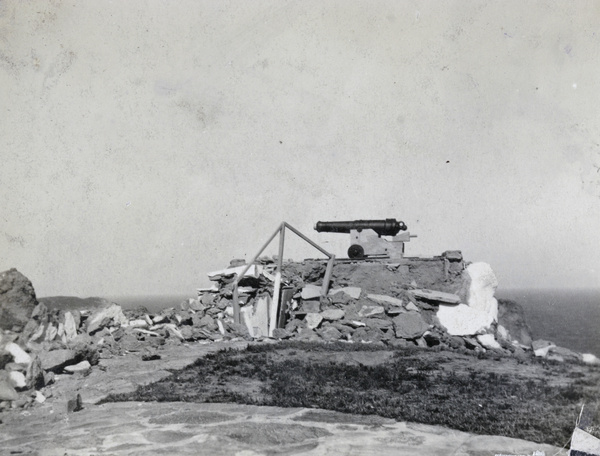 Cannon, with rubble from damaged buildings by lighthouse