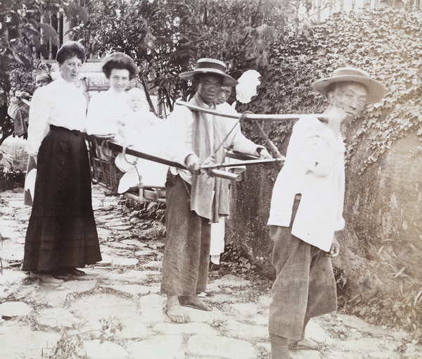 Bearers carrying a young woman with a baby in a sedan chair