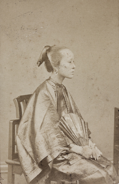 Portrait of a woman in profile, with a fan