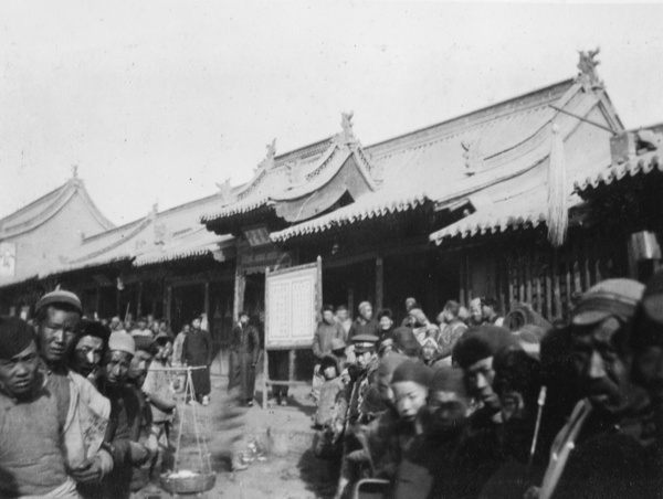 Crowd near notice board in street