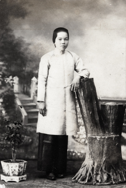 Studio portrait of a woman with a rustic tree stump chair