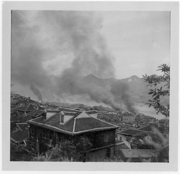 Steam/fumes cleared away and fires burning, after bombing, Chongqing