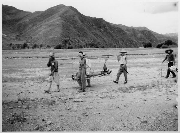 A stretcher party carrying a person to hospital 