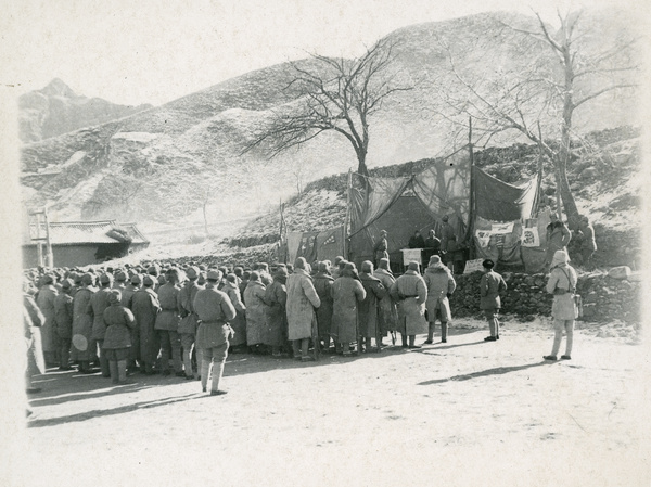 Soldiers at a mass meeting in front of a stage