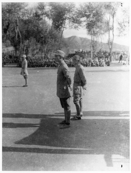 Two Eighth Route Army men watching an event with other soldiers