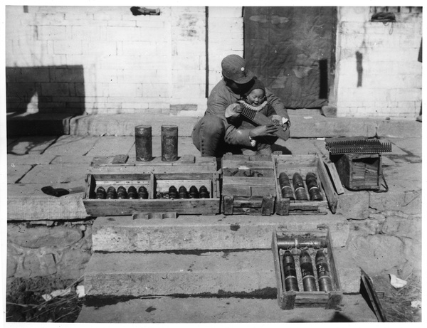 Erica Lindsay playing with machine gun cartridges, with 2nd Sub-district Chief of Staff and captured Japanese munitions, Qian Tan, Jinchaji