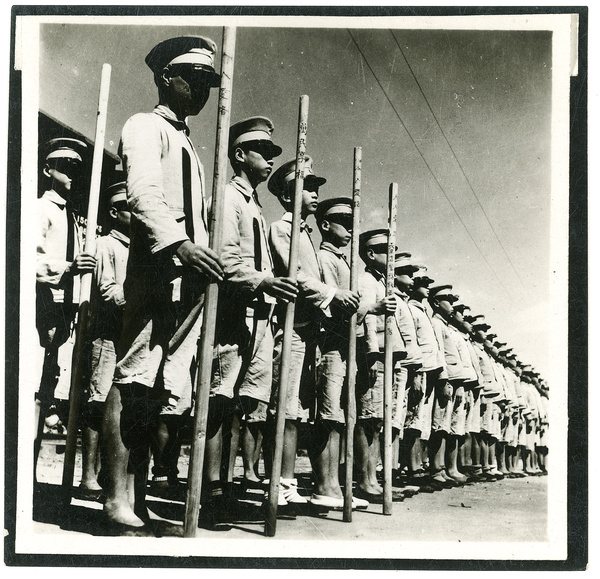 Ranks of soldiers with staves carved with Chinese characters