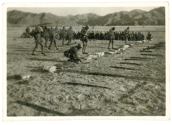Bedding and weapons laid out in a row for inspection