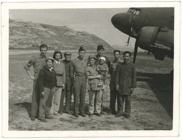 Hsiao Li Lindsay (李效黎) and baby Erica Lindsay, with others, beside a Douglas C-47 Skytrain, after the arrival at Yan'an (延安) of the U.S. Army Observers Section, 1944