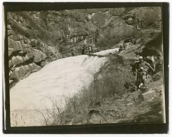 Soldiers crossing a snowy mountain gulley