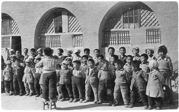 Yan'an Nursery School children singing, conducted by a child on a stool, Yan'an (延安)