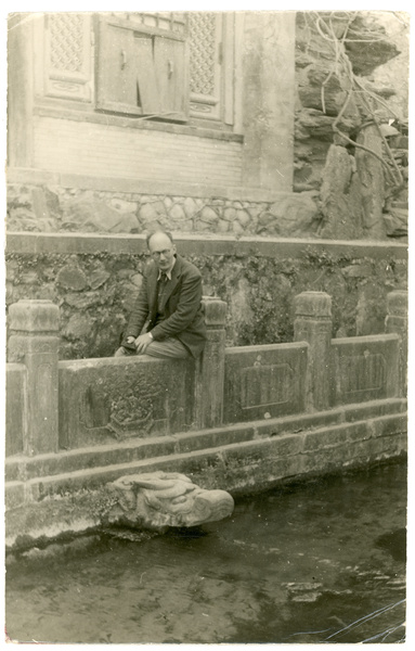 Michael Lindsay (林迈可) looking at a stone dragon head water spout (dragon-headed gargoyle)