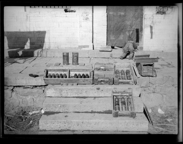 Erica Lindsay playing near a display of captured Japanese munitons, 2nd Sub-district, Jinchaji