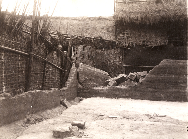 People peering over matting and fallen down walls