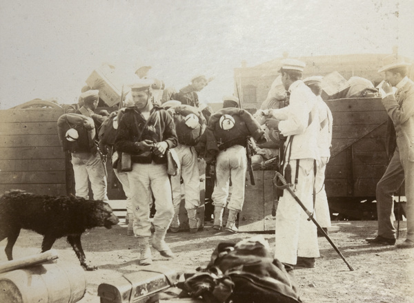 Soldiers loading luggage onto a railway carriage