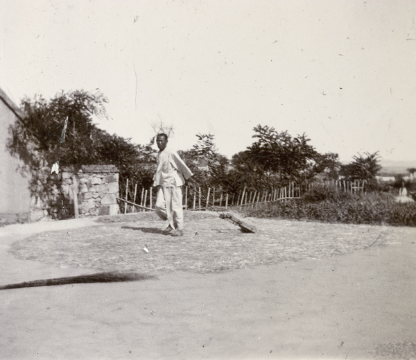 Man pulls small thresher in yard, Weihaiwei