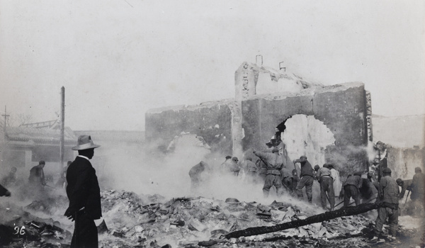 Raking over smouldering remains after a fire (Peking Mutiny), Beijing, 1912