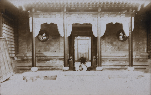 Seated man with dogs, by doorway