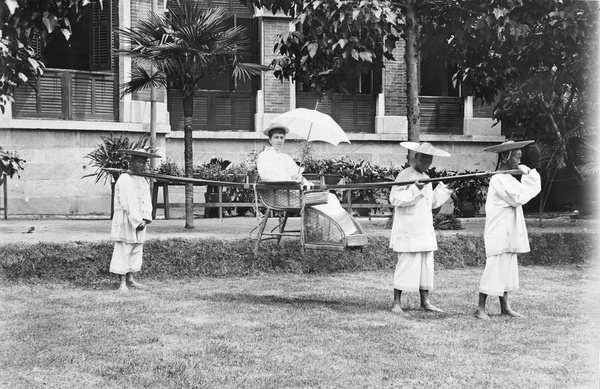 A woman in a sedan chair, with three bearers