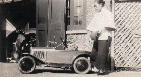 Colin Attwell Lynch Palmer in a pedal car, with his amah, Shanghai